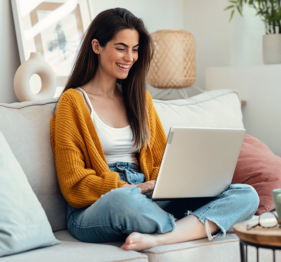 Woman sitting on couch working on her laptop
