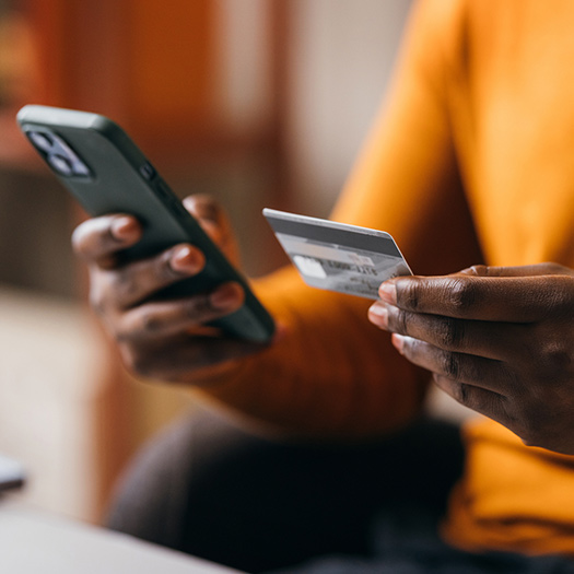 Person using their credit card and phone.