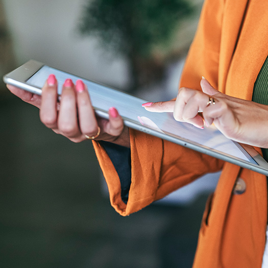 Business person typing on a tablet.