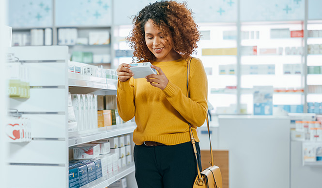 Woman checking a prescription box at pharmacy.