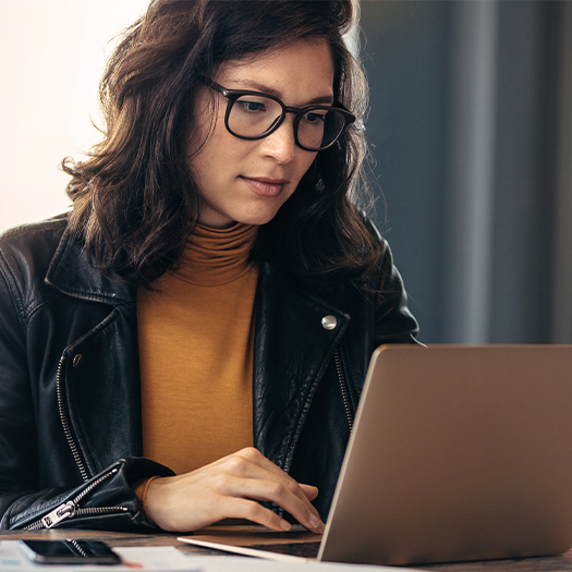 Asian woman busy working on laptop computer at office.