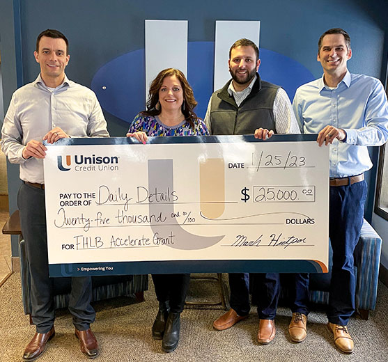Unison Credit Union presenting Daily Details a check