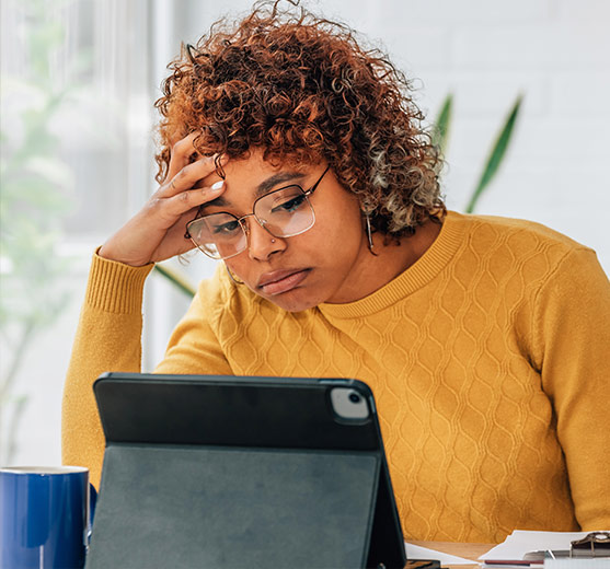 Woman working on laptop, seems frustrated.