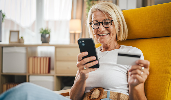 Mature senior woman buy online with credit card and on mobile phone at home
