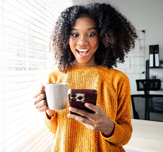 Woman drinking coffee and on her phone.