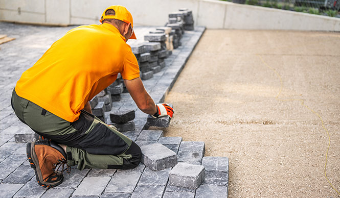 Construction worker laying bricks for patio