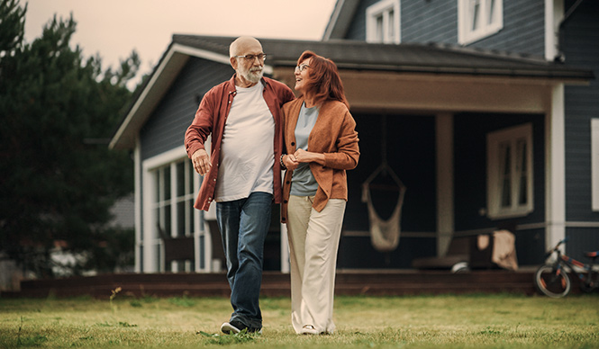 Man and woman walking in their front yard.