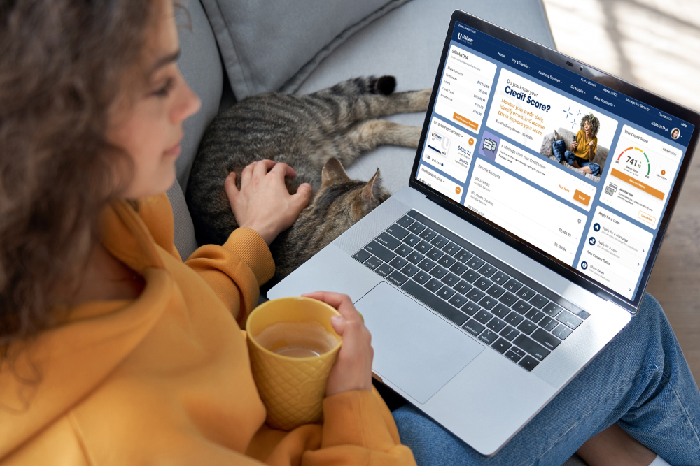 Lady with cat on couch looking at updated online banking layout